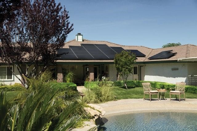 Solar panels on house from the backyard with pool